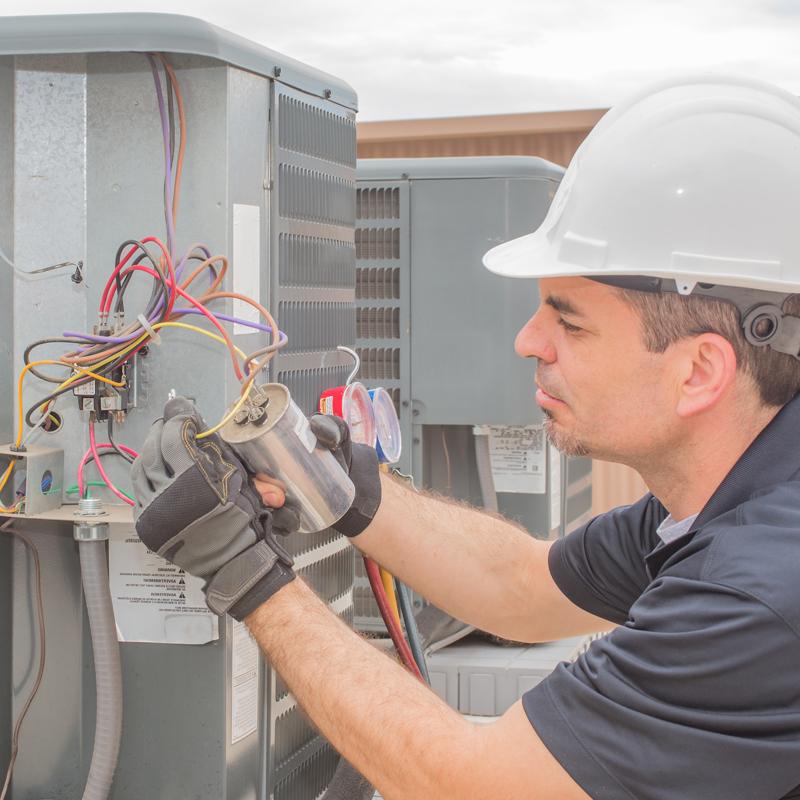 man connecting wires on a unit