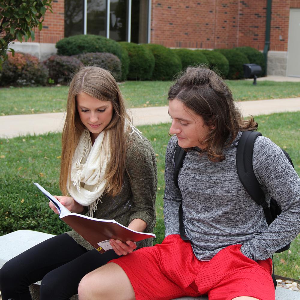 two students looking at a college book
